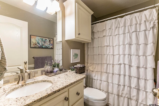 bathroom featuring vanity, a textured ceiling, toilet, and a shower with shower curtain