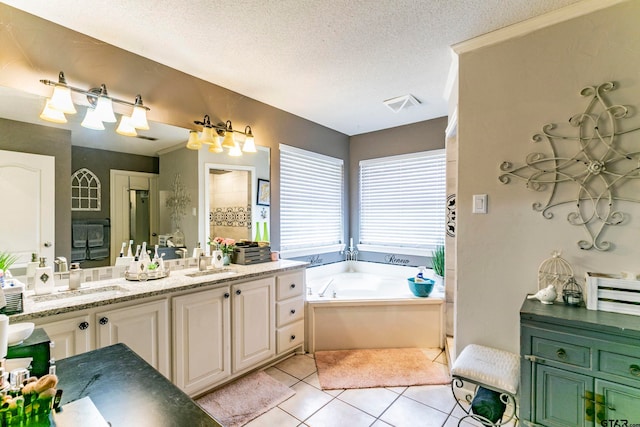 bathroom featuring vanity, a textured ceiling, tile patterned floors, and a bathing tub