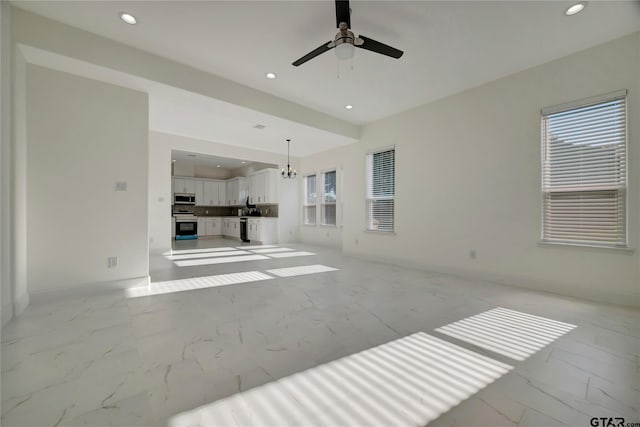 unfurnished living room featuring recessed lighting, marble finish floor, and baseboards