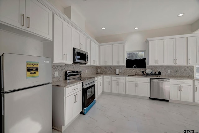 kitchen with white cabinets, marble finish floor, appliances with stainless steel finishes, and decorative backsplash