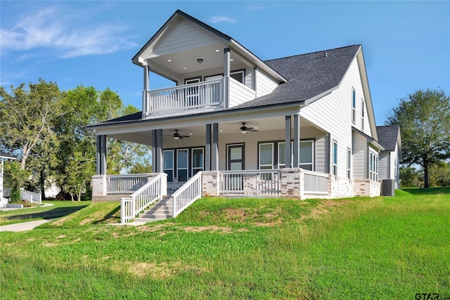 view of front facade featuring a porch, ceiling fan, a balcony, cooling unit, and a front lawn