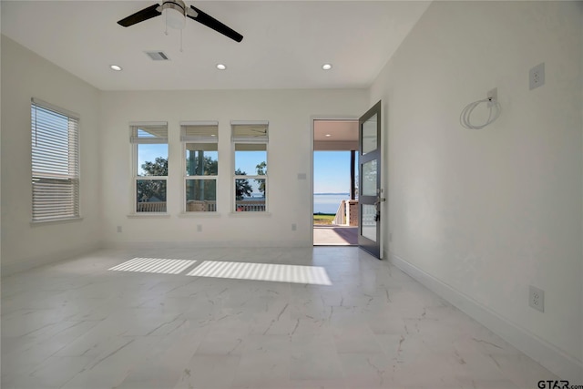 empty room with marble finish floor, recessed lighting, visible vents, and baseboards