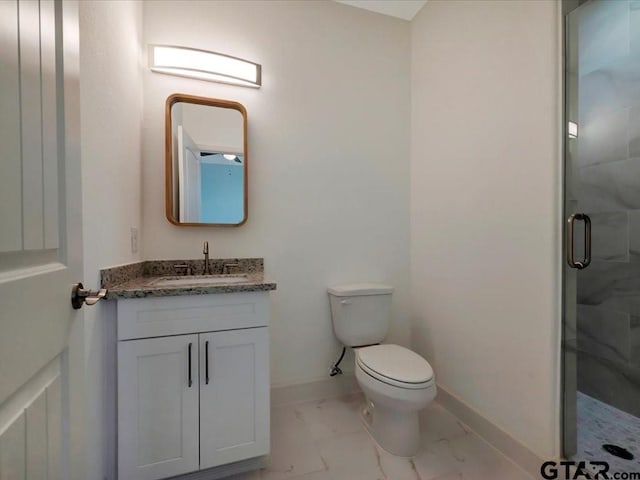 full bath featuring marble finish floor, vanity, baseboards, and a stall shower