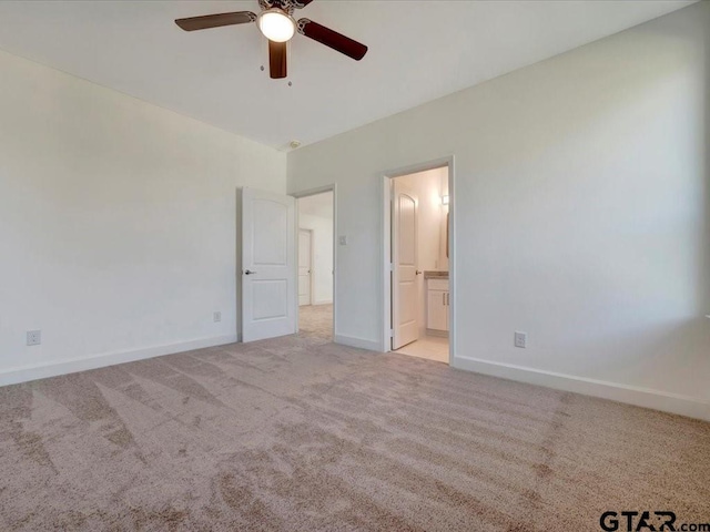 unfurnished bedroom featuring carpet, baseboards, ceiling fan, and ensuite bathroom