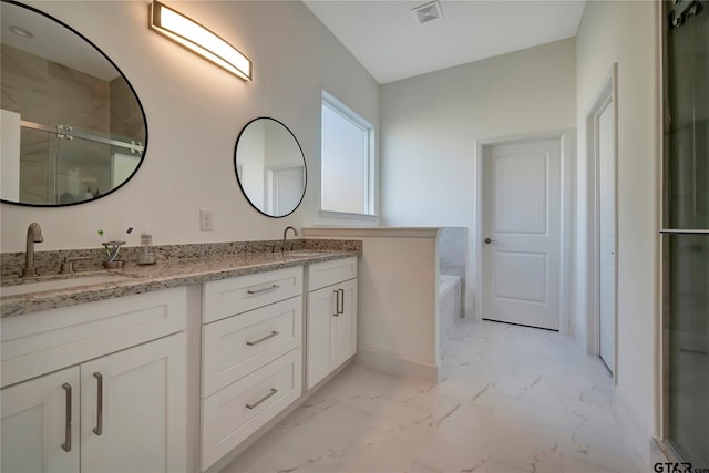 bathroom featuring a garden tub, a sink, marble finish floor, double vanity, and a stall shower