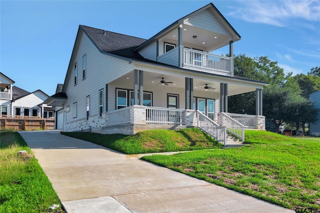 view of front facade featuring a porch, a balcony, a front lawn, and a ceiling fan