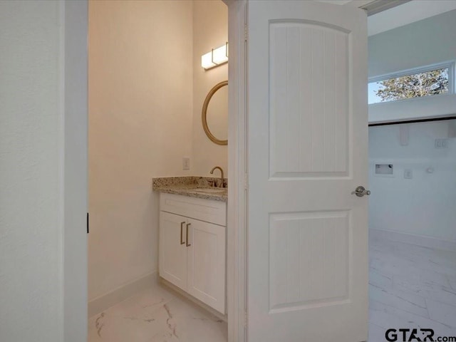 bathroom featuring marble finish floor, baseboards, and vanity