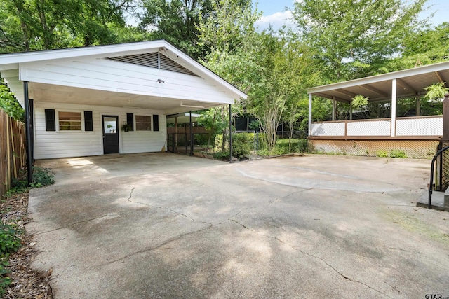 exterior space featuring fence, a carport, and concrete driveway