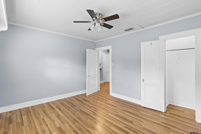 unfurnished bedroom featuring baseboards, ornamental molding, visible vents, and light wood-style floors
