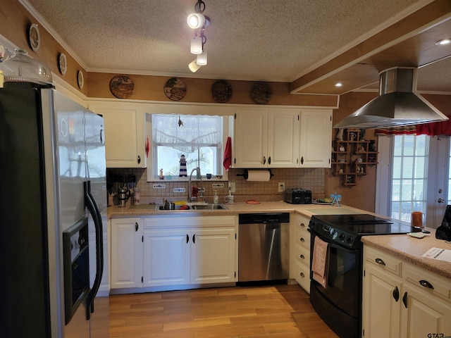 kitchen featuring a wealth of natural light, appliances with stainless steel finishes, exhaust hood, and white cabinets