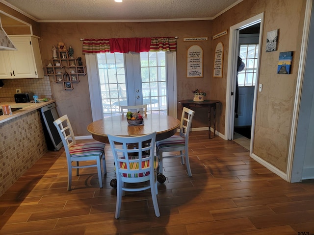 dining area featuring ornamental molding, dark hardwood / wood-style flooring, and a textured ceiling