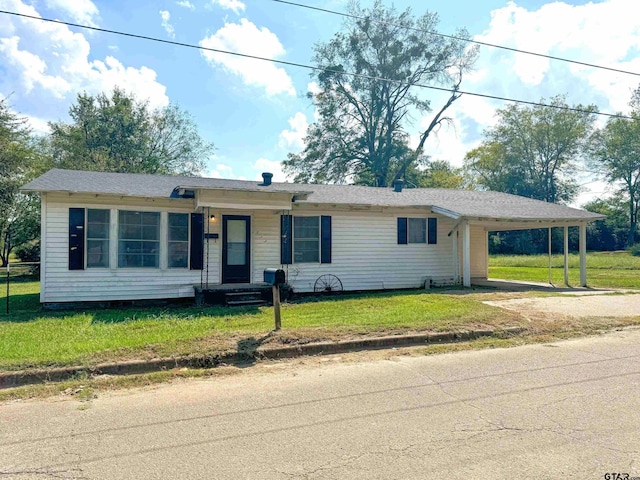 ranch-style home with a front yard and a carport