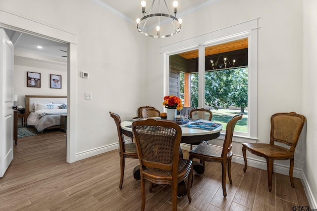 dining space with hardwood / wood-style floors, a notable chandelier, and crown molding