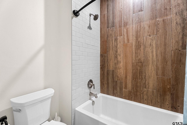 bathroom with toilet and tiled shower / bath