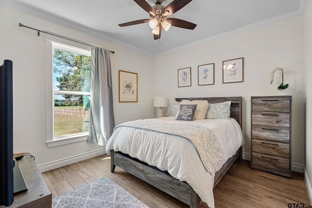 bedroom with ceiling fan, wood-type flooring, and ornamental molding