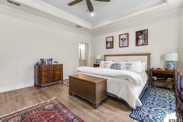 bedroom featuring wood-type flooring, a raised ceiling, ceiling fan, and crown molding