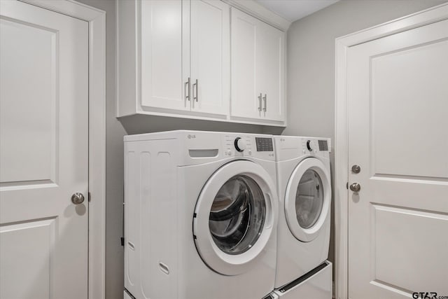 clothes washing area with cabinet space and independent washer and dryer