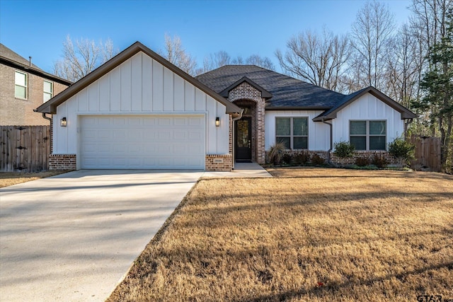 view of front of home featuring driveway, fence, board and batten siding, an attached garage, and brick siding