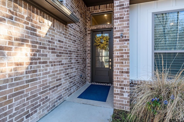 doorway to property with brick siding