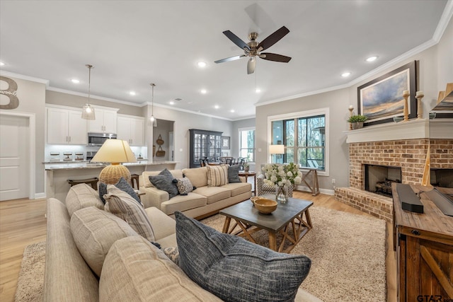 living room featuring a brick fireplace, recessed lighting, light wood-style flooring, and baseboards