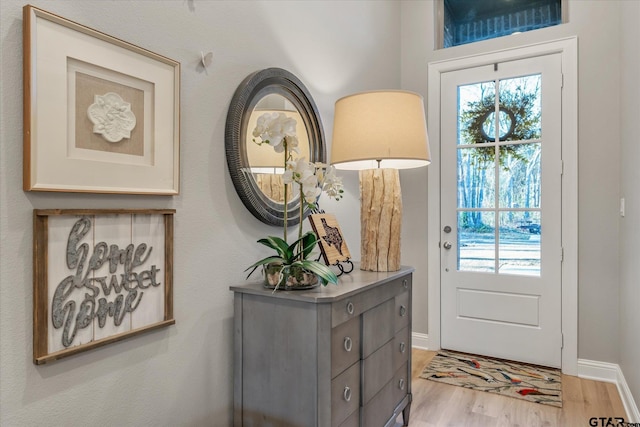 doorway to outside featuring a wealth of natural light, light wood-type flooring, and baseboards