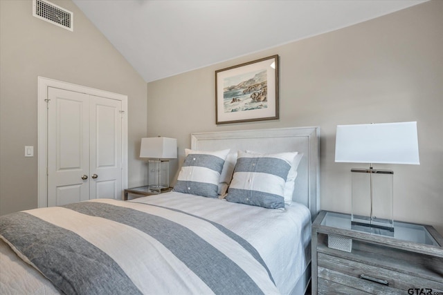 bedroom with a closet, visible vents, and lofted ceiling