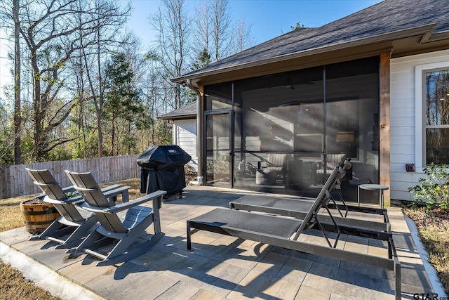 view of patio / terrace with a sunroom, area for grilling, and fence