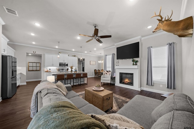 409 Meadow Ln, Chandler, TX 75758 - living room featuring ceiling fan, crown molding, recessed lighting, dark wood-style flooring, and a glass covered fireplace