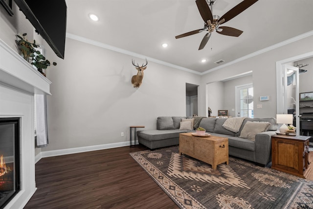 409 Meadow Ln, Chandler, TX 75758 - living room with a warm lit fireplace, dark wood finished floors, a ceiling fan, ornamental molding, and recessed lighting