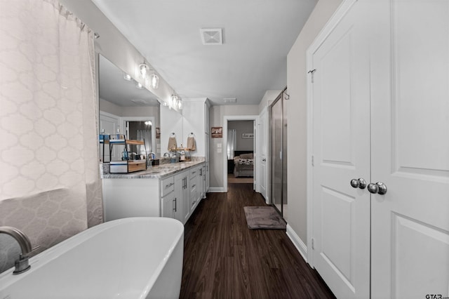 409 Meadow Ln, Chandler, TX 75758 - bathroom featuring a freestanding tub, wood finished floors, vanity, and ensuite bath