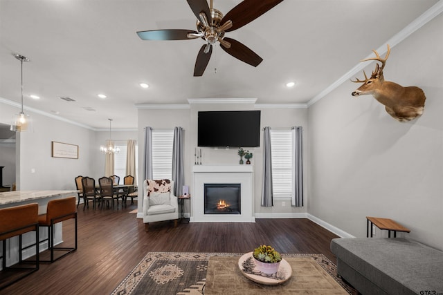 409 Meadow Ln, Chandler, TX 75758 - living room with ceiling fan, dark wood-style flooring, crown molding, a chandelier, and a glass covered fireplace