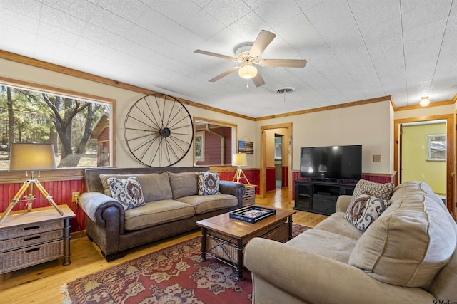 living area featuring visible vents, wainscoting, ceiling fan, wood finished floors, and crown molding