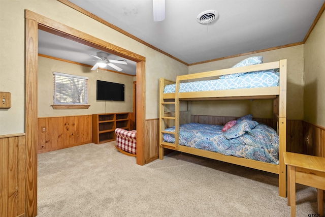 bedroom featuring carpet floors, visible vents, ornamental molding, and wainscoting