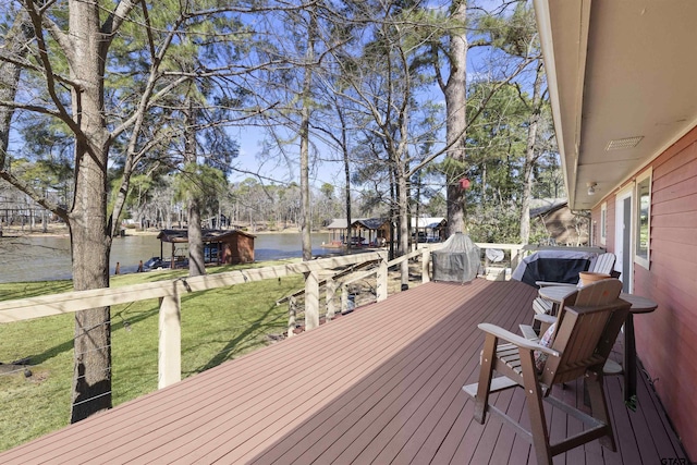 wooden deck with a lawn and a water view