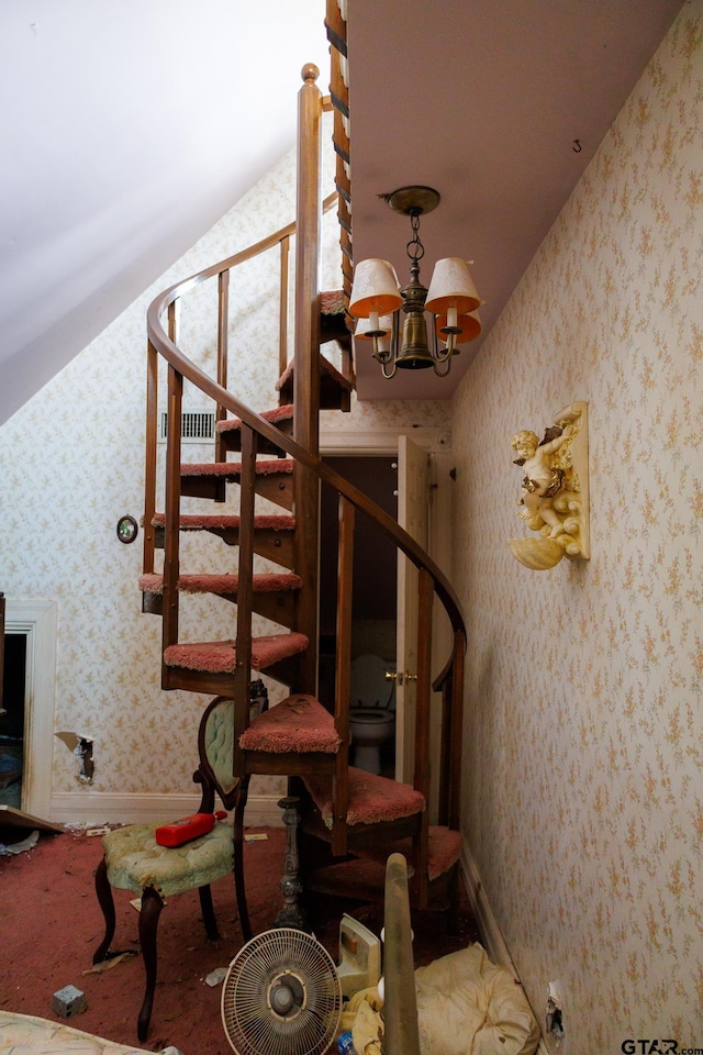 staircase featuring an inviting chandelier