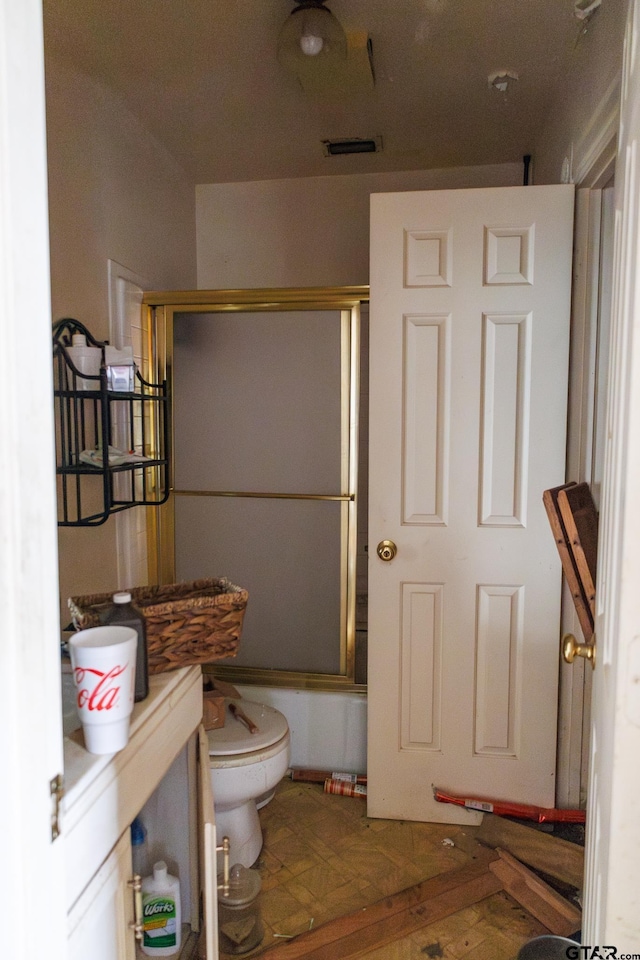 bathroom featuring toilet and enclosed tub / shower combo