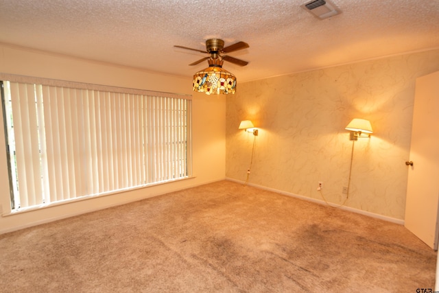 unfurnished room featuring ceiling fan, carpet floors, and a textured ceiling