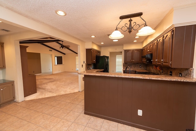 kitchen with light carpet, ceiling fan with notable chandelier, black refrigerator, decorative backsplash, and a textured ceiling