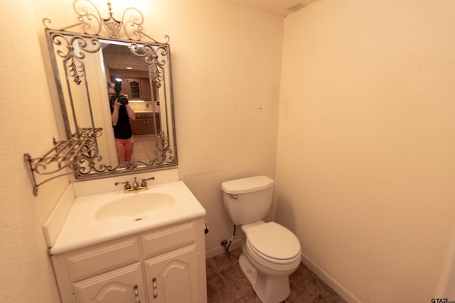 bathroom with tile patterned flooring, vanity, and toilet