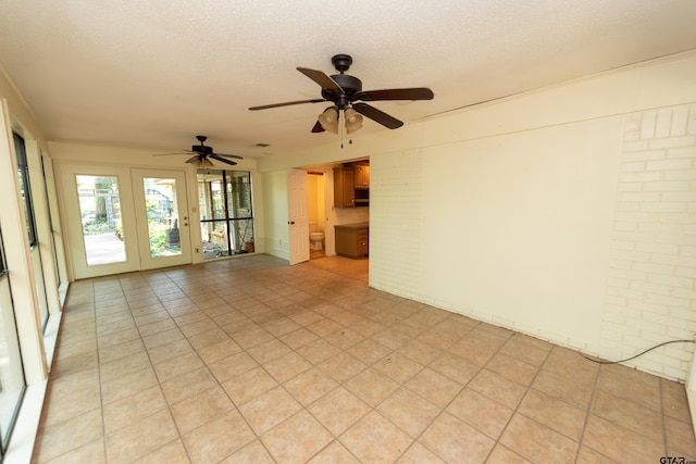 empty room with ceiling fan and a textured ceiling