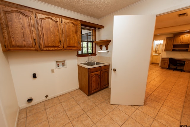 washroom featuring sink, cabinets, hookup for a washing machine, a textured ceiling, and light tile patterned flooring