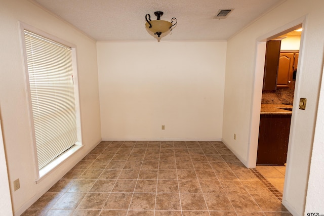 interior space with light tile patterned floors and a textured ceiling