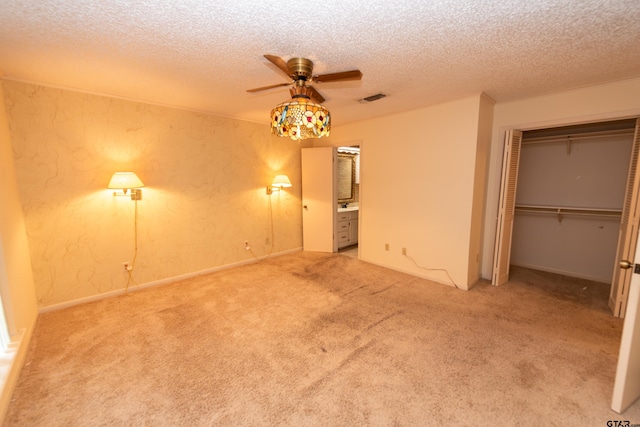 unfurnished bedroom featuring carpet flooring, a textured ceiling, and ceiling fan