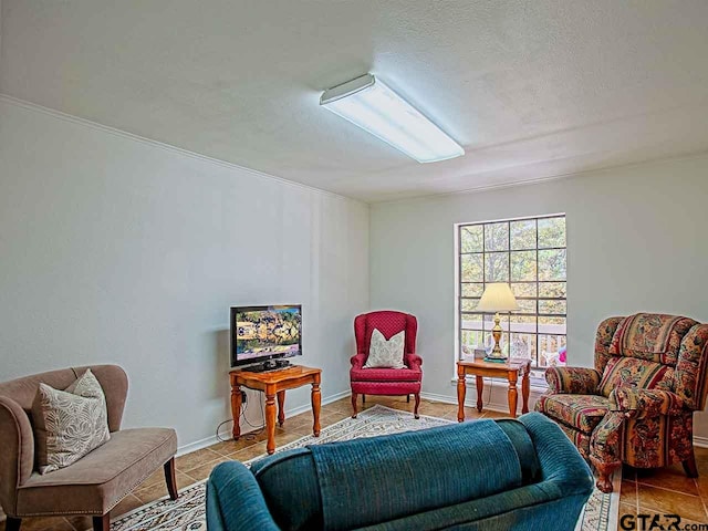 sitting room featuring a textured ceiling, ornamental molding, and light tile patterned floors