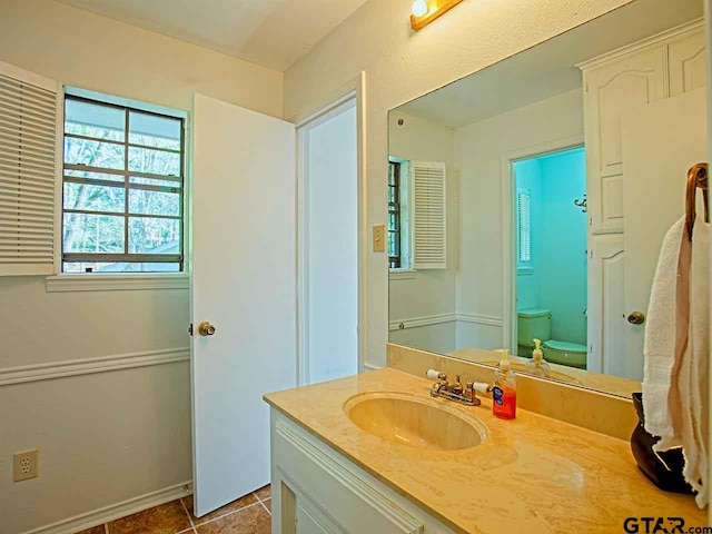 bathroom featuring toilet, vanity, and tile patterned floors