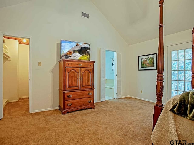 carpeted bedroom with high vaulted ceiling and ensuite bath