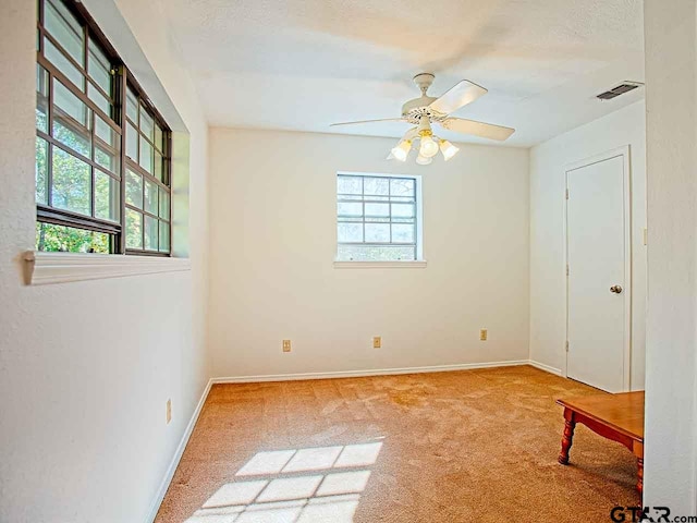 unfurnished room featuring carpet, plenty of natural light, and ceiling fan