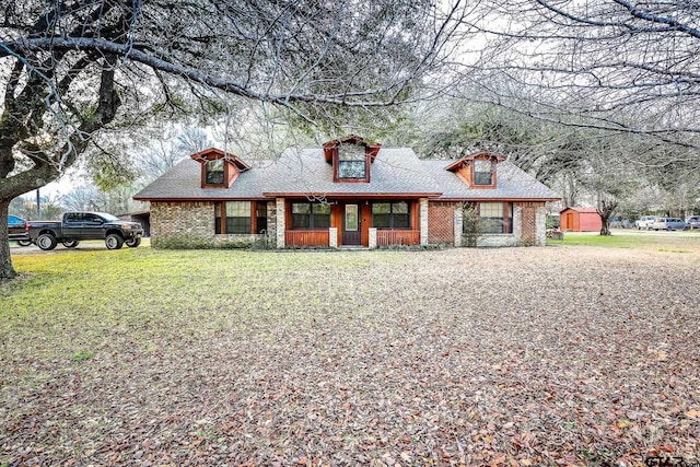 view of front facade featuring brick siding and a shingled roof