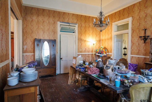 dining room featuring dark hardwood / wood-style flooring, crown molding, and a notable chandelier