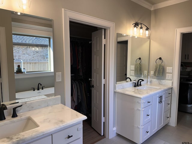 full bathroom featuring a sink, a walk in closet, two vanities, and ornamental molding